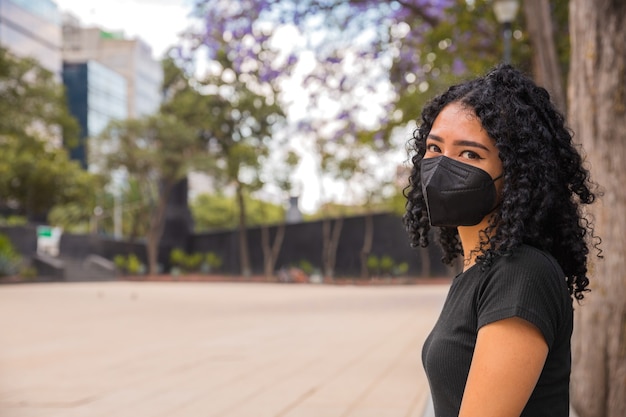 写真 巻き毛の若い女性が公園に座っています