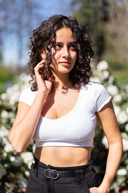 Young woman with curly hair in the park enjoying the sunshine