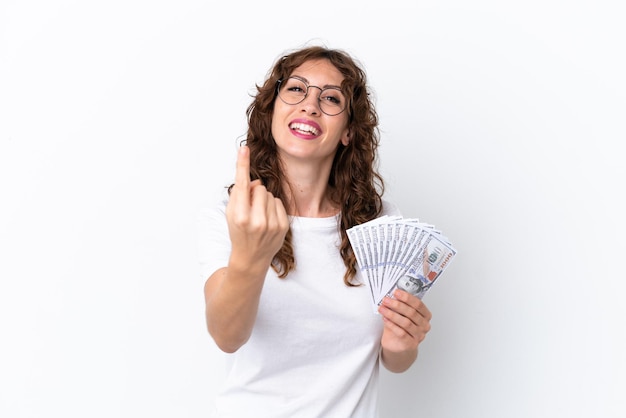 Young woman with curly hair taking a lot of money isolated background on white background doing coming gesture