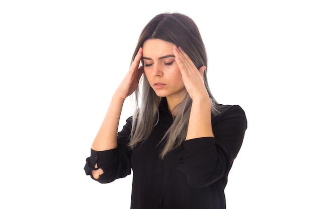 Young woman with dark hair  in black shirt having a headache on white background in studio