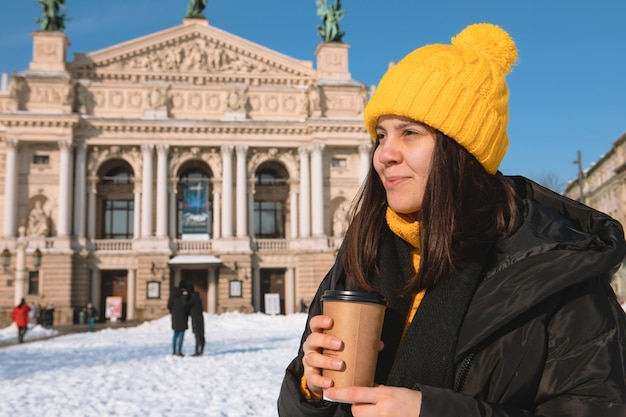 コーヒーを飲む使い捨てカップを持つ若い女性