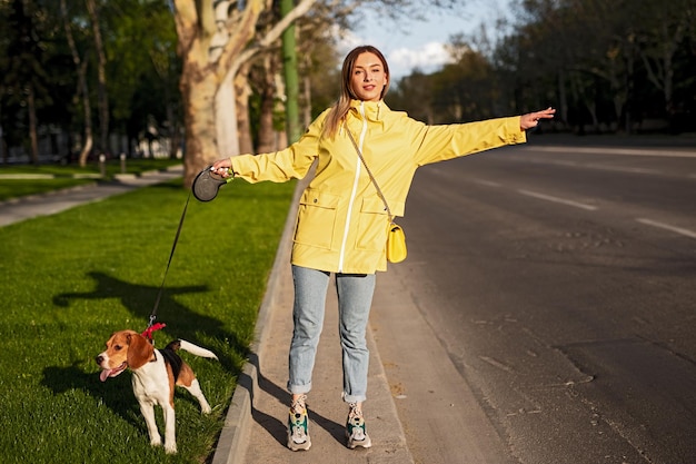 公園の近くの車を引く犬を持つ若い女性