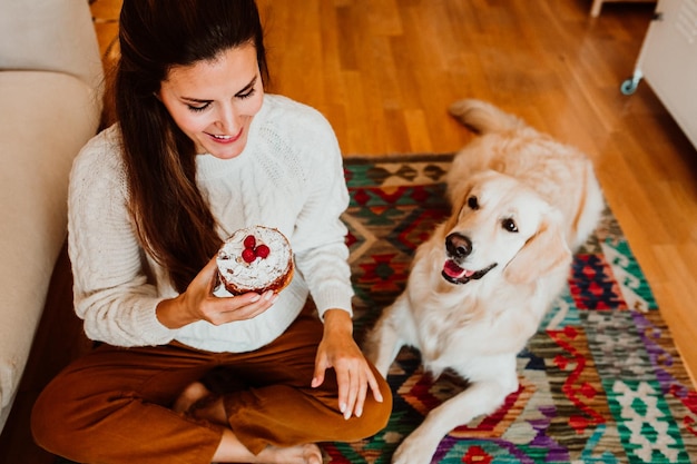 Photo young woman with dog sitting on floor at home