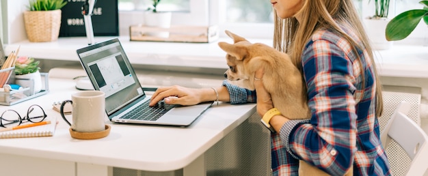 自宅で仕事をしている犬と若い女性