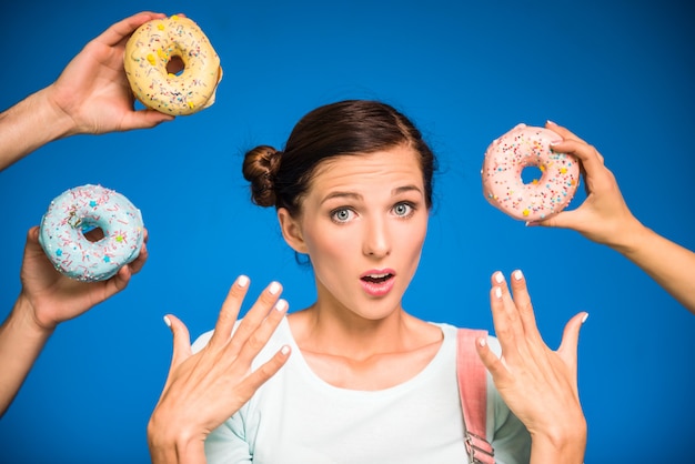 Young woman with donuts standing