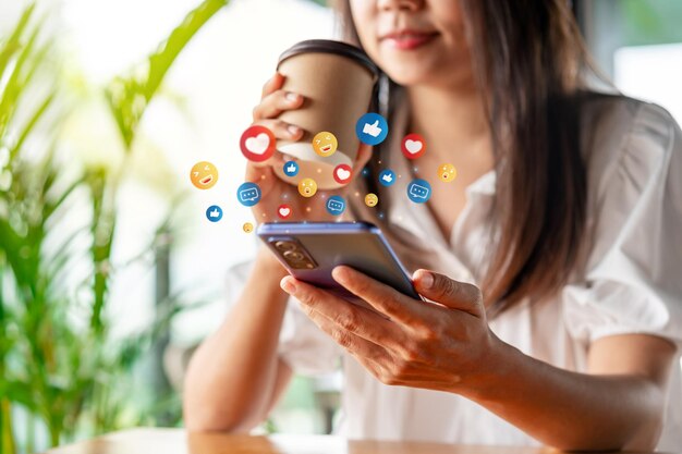 Young woman with drinks using mobile phone and relaxing in cafe Modern lifestyle and social media concept