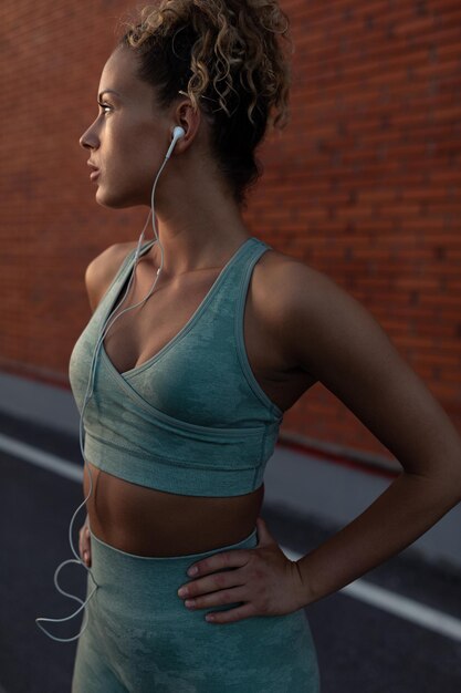 Young woman with earphones during a workout outdoors