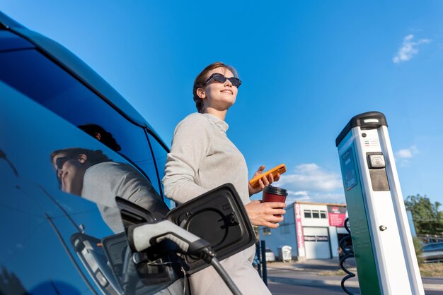 Young woman with an electric car at charging station in Chisinau Moldova