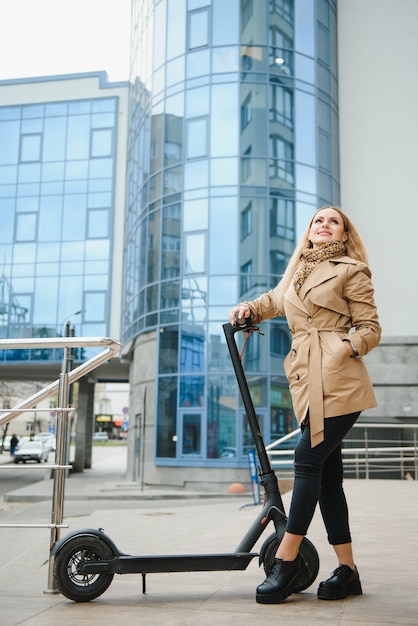 Foto giovane donna con scooter elettrico in città