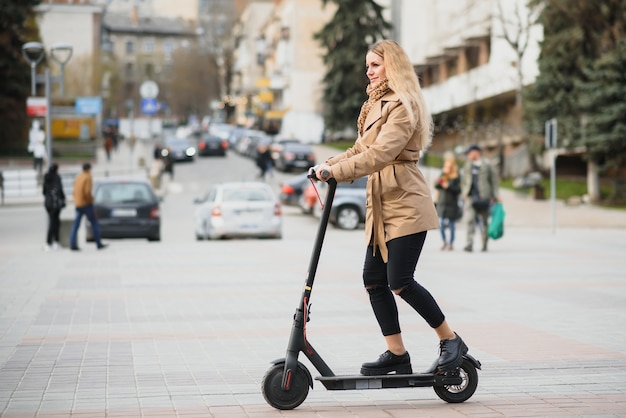 Young woman with electric scooter in the city