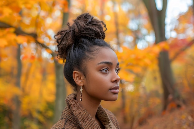 A young woman with an elegant hairstyle stands amidst a forest of autumn leaves her expression contemplative