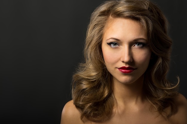 Young woman with evening make-up suit on a black background