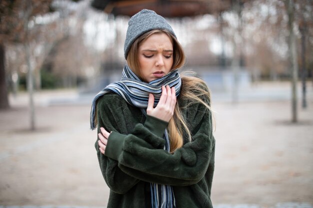 Young woman with eyes closed standing on field during winter