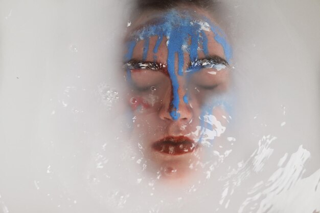 액체 속 에 얼굴 페인트 를 쓴 젊은 여자