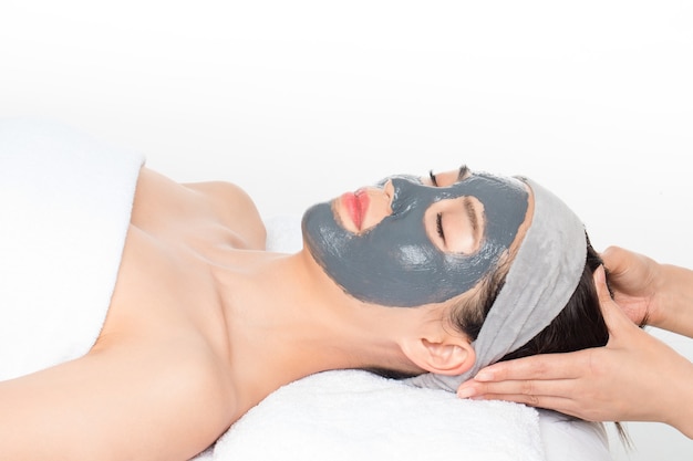 Young woman with facial mask in beauty salon