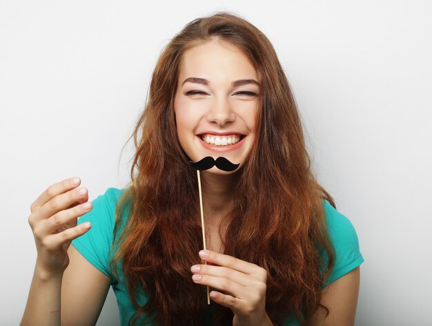 Young woman with fake mustaches. Ready for party.