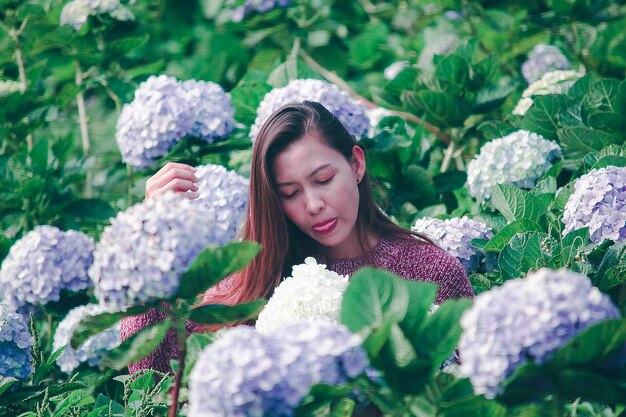 Young woman with flower petals on plants