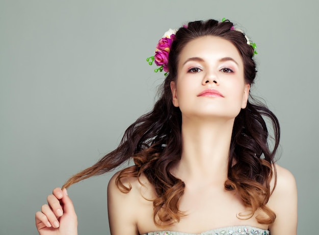 Young Woman with Flowers in Hair Portrait Cute Prom Girl with Perfect Hairstyle and Makeup on Grey Background