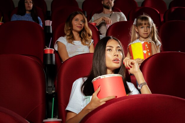 Giovane donna con gli amici a guardare film al cinema