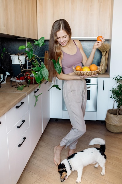 Young woman with fruits in the kitchen Healthy vegan food at home