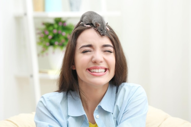 Young woman with funny rat at home