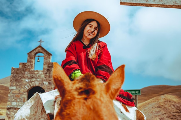Young woman with gaucho costume riding a horse