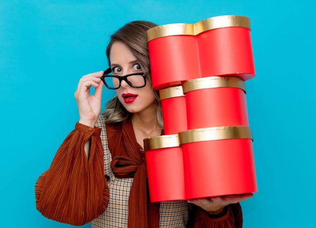 Young woman with gift boxes on blue