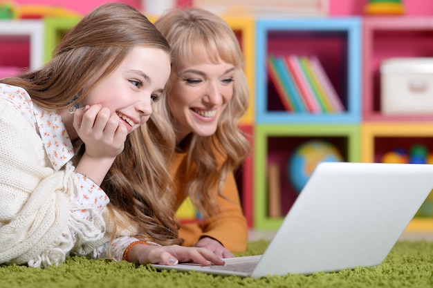 Young woman with girl using laptop