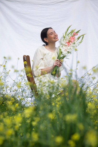 Young woman with gladiolus in nature