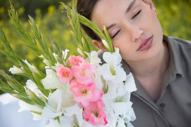 Photo young woman with gladiolus in nature