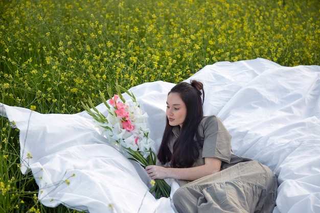 Foto giovane donna con gladiolo in natura