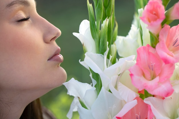 Giovane donna con gladiolo in natura