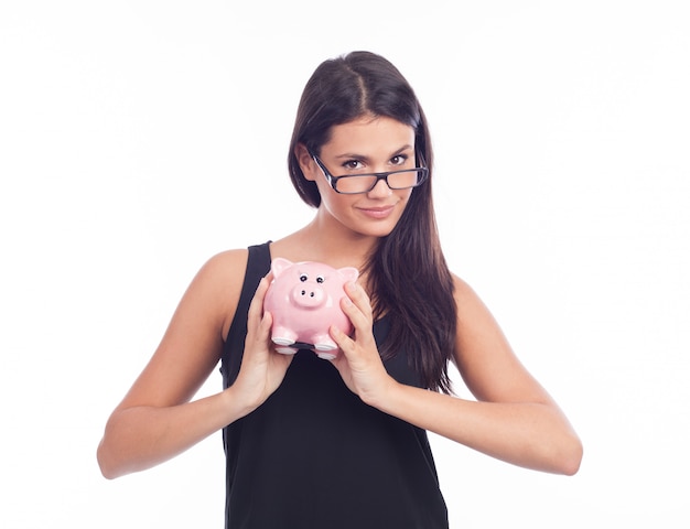 Young woman with glasses happy with piggy bank