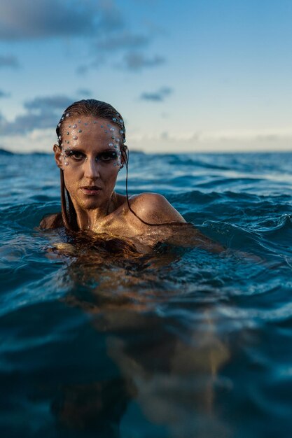 Young woman with golden skin in water