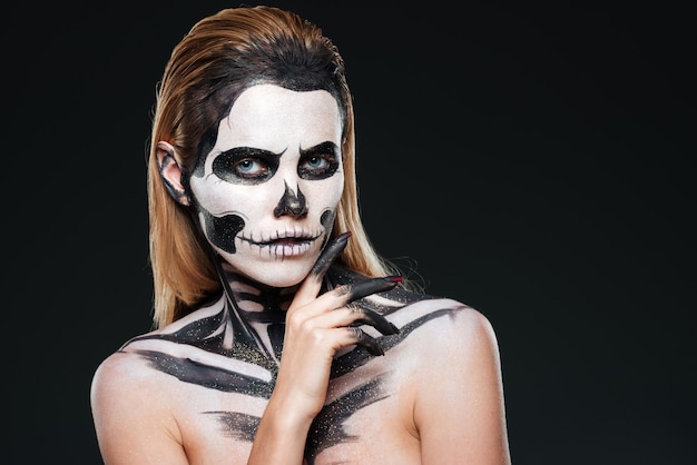 Photo young woman with gothic skeleton makeup over black background