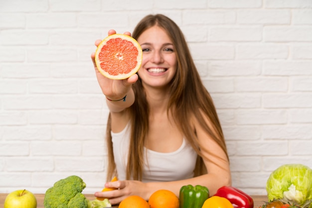 Young woman with a grapefruit ina kitchen