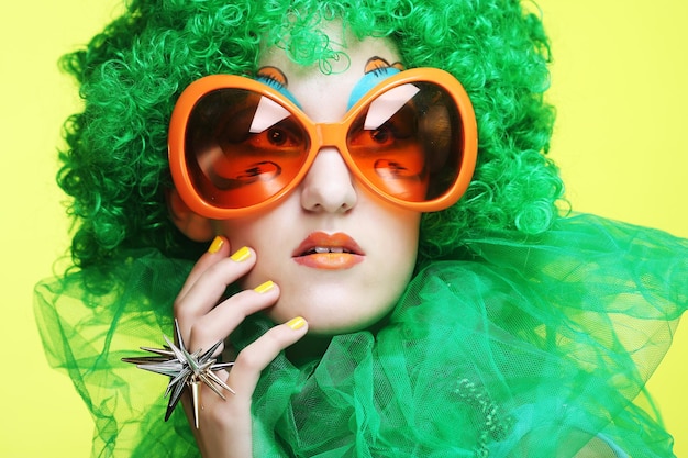 Young woman with green hair and carnaval glasses