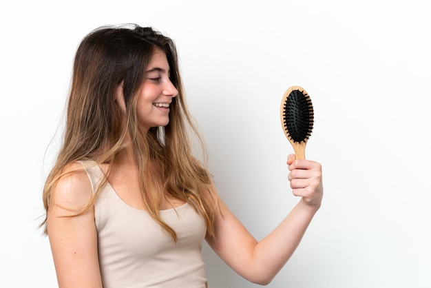 Young woman with hair comb isolated on white background with happy expression