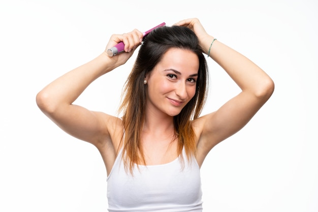 Young woman with hair comb over isolated white wall