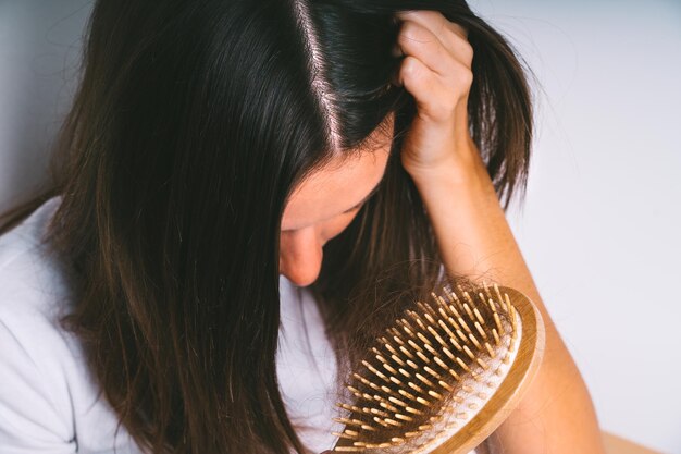 Young woman with hair loss problem Hair falling out Hair brush with hair