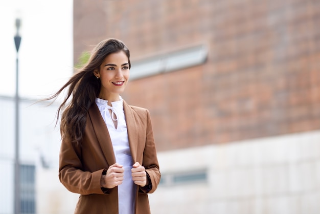 Young woman with hair in the wind in urban background