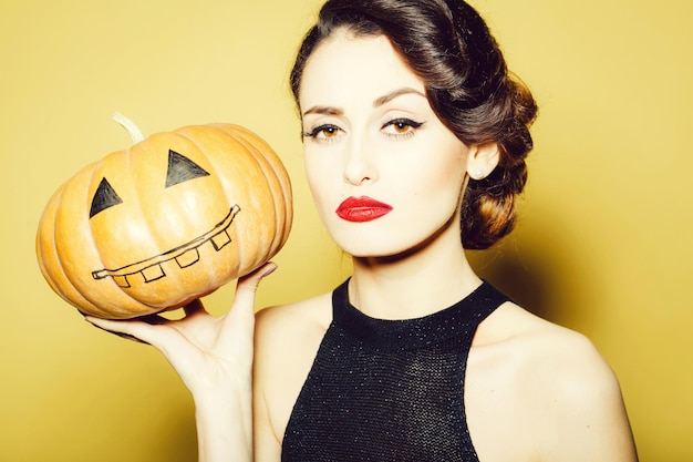 Foto giovane donna con la zucca di halloween