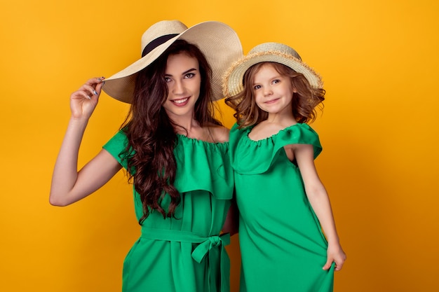 Young woman with hand on waist standing with small daughter