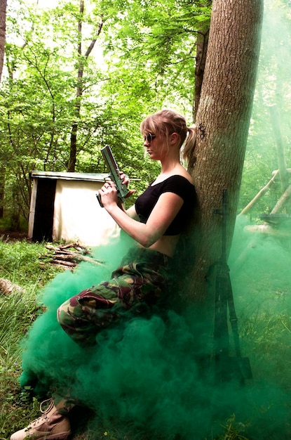 Фото Молодая женщина с пистолетом в лесу