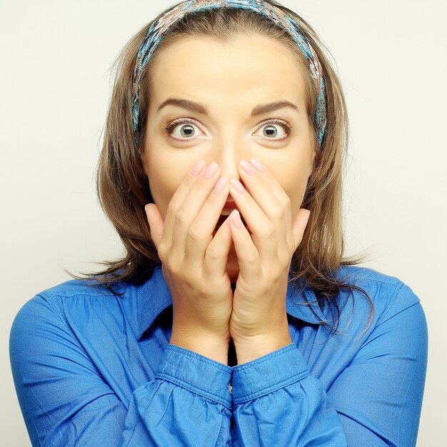 Young woman with hands over mouth.