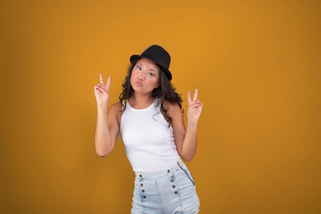 Young woman with hat making cute face isolated from the background