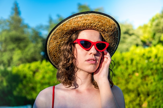 Photo young woman with hat red sunglasses in bikini glamour girl outdoors enjoying summer vacation