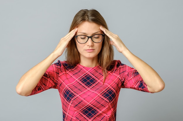 Young woman with a headache touching head