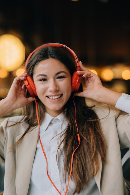 Young woman with headphones listen music while sitting in cafes