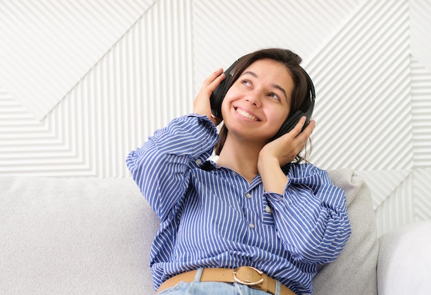 Young woman with headphones listening music Music teenager girl dancing against white background